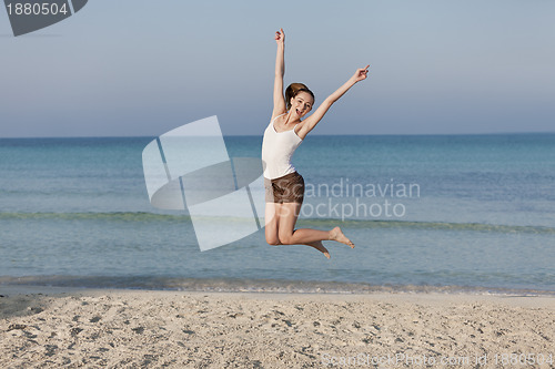 Image of Woman cherfull jumping on beach landscape