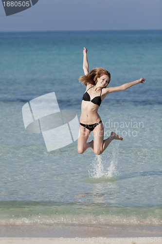 Image of Woman with bikini jumping in the sea hochformat