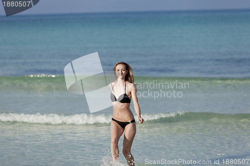 Image of Woman with bikini in the sea jumping landscape
