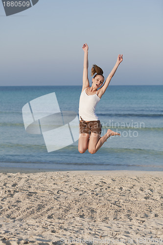 Image of Cheerful woman jumping laughing at beach portrait