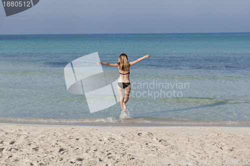 Image of Woman with bikini in the sea jumping landscape