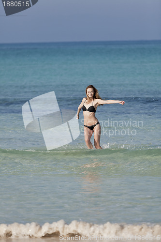 Image of Woman with bikini in the sea jumping portrait