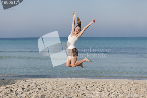 Image of Woman cherfull jumping on beach landscape