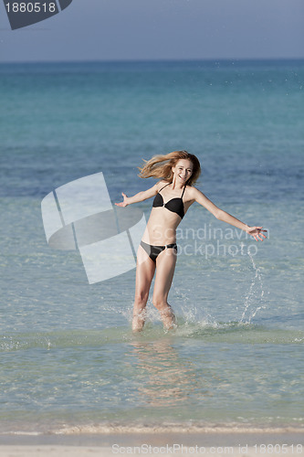 Image of Woman with bikini jumping in the sea hochformat