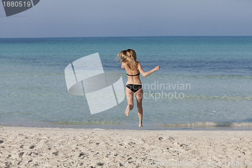 Image of Woman with bikini in the sea jumping landscape