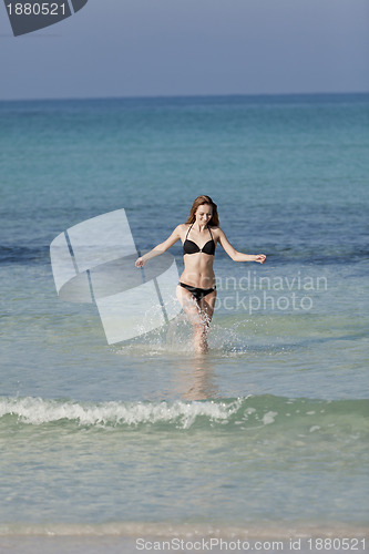 Image of Woman with bikini in the sea jumping portrait