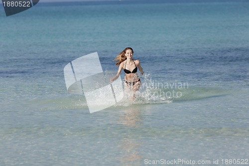 Image of Woman with bikini in the sea jumping landscape