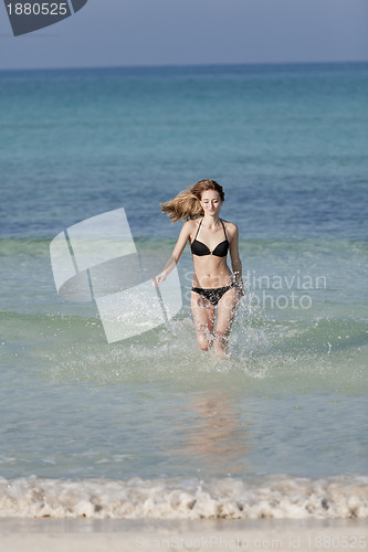 Image of Woman with bikini in the sea jumping portrait