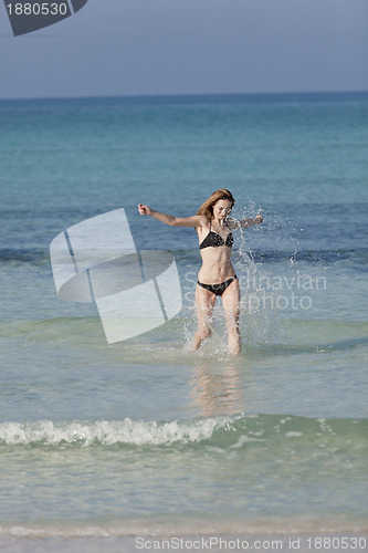 Image of Woman with bikini in the sea jumping portrait