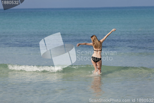 Image of Woman with bikini in the sea jumping landscape