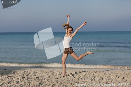 Image of Woman cherfull jumping on beach landscape