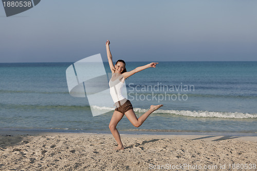 Image of Woman cherfull jumping on beach landscape