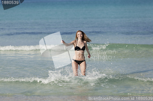 Image of Woman with bikini in the sea jumping landscape