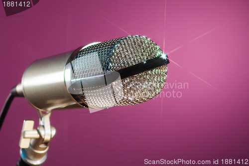 Image of metallic microphone on pink background