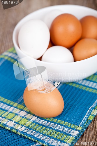 Image of eggs in a bowl, towel and feathers 