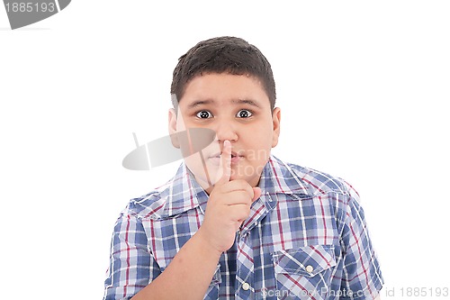 Image of Portrait of beautiful little boy with silence gesture over white