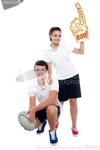 Image of Cheerleader fan girl posing with football team player