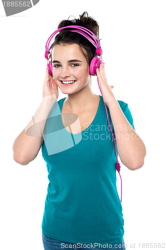 Image of Cheerful pretty girl listening to music