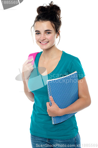 Image of College student carrying backpack and spiral notebook