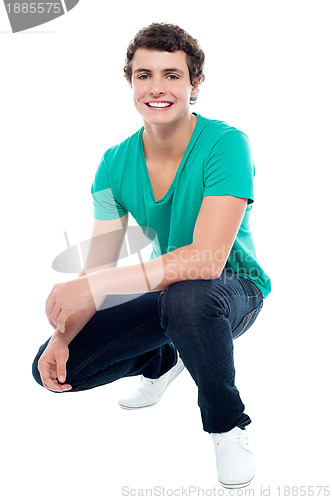 Image of Cool guy wearing white sneakers, squatting posture