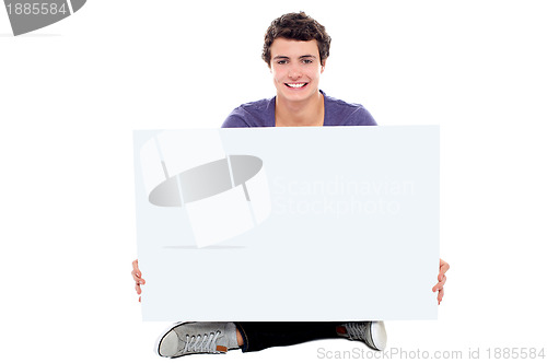 Image of Teenager showing blank white billboard to camera