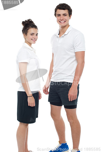 Image of Teen couple in sportswear posing casually