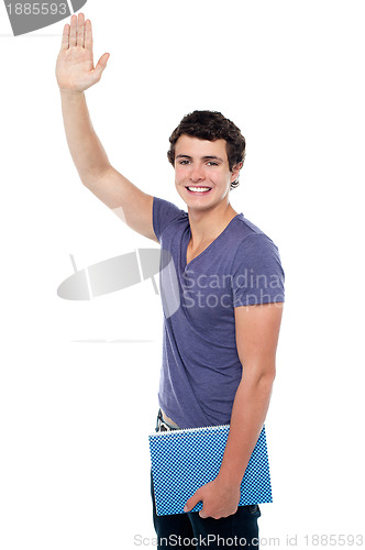 Image of Handsome young guy putting his right hand up