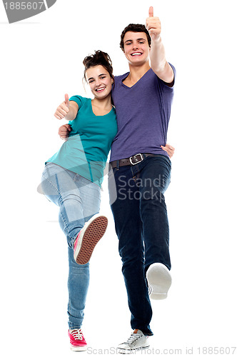 Image of Teen love couple enjoying themselves, gesturing thumbs up