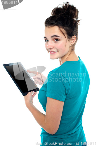 Image of Trendy young casual girl operating tablet device