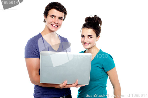 Image of Charming teen couple holding a laptop