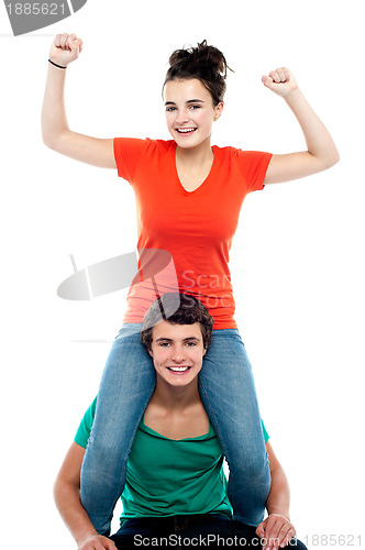 Image of Excited pretty girl enjoying riding on his friends shoulder