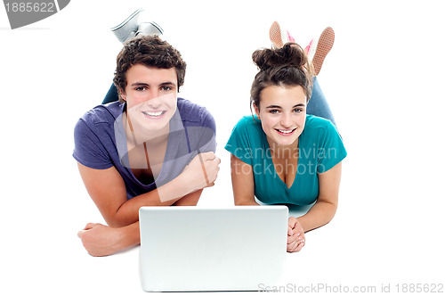 Image of Teen friends enjoying video on laptop together