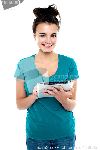 Image of Pretty young brunette using wireless tablet device