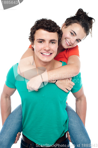 Image of Casual shot of young guy giving piggy ride to his partner