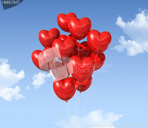 Image of red heart shaped balloons floating in the sky