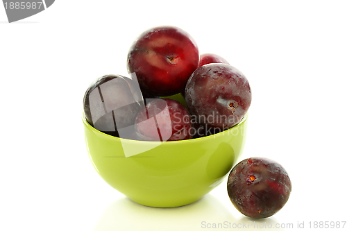 Image of Ripe plums in green bowl. 