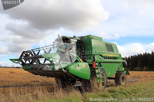 Image of Modern combine harvester by wet field