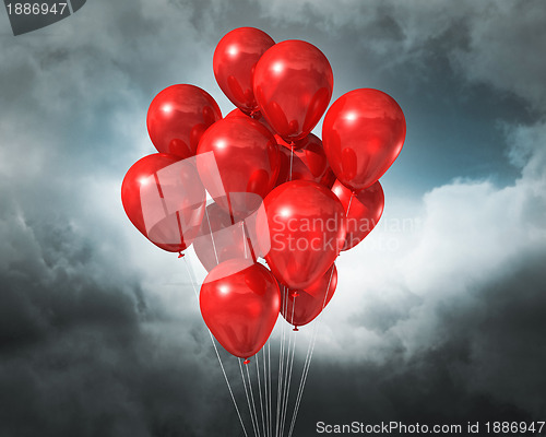 Image of red balloons on a cloudy dramatic sky