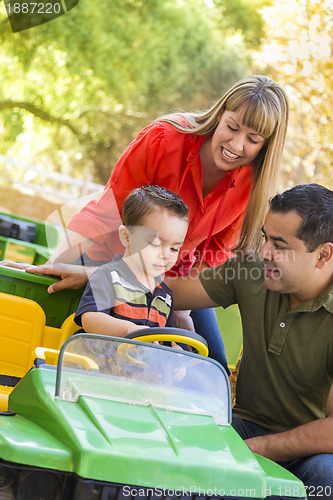 Image of Young Mixed Race Boy Enjoys Toy Tractor with Parents