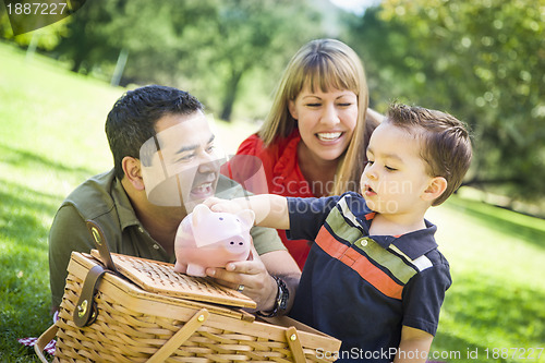 Image of Mixed Race Couple Give Their Son a Piggy Bank at the Park