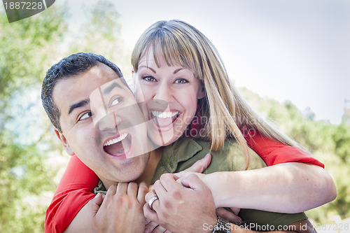 Image of Attractive Mixed Race Couple Piggyback at the Park