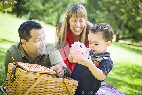 Image of Mixed Race Couple Give Their Son a Piggy Bank at the Park