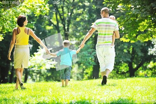 Image of happy young couple with their children have fun at park