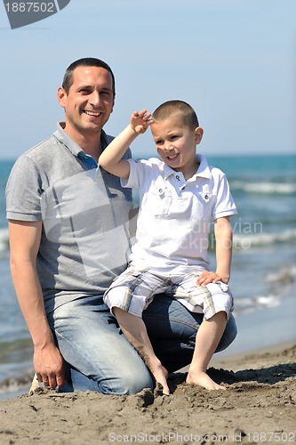 Image of happy father and son have fun and enjoy time on beach