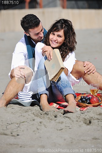 Image of young couple enjoying  picnic on the beach