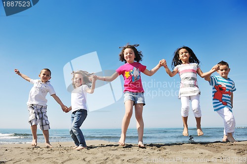 Image of happy child group playing  on beach