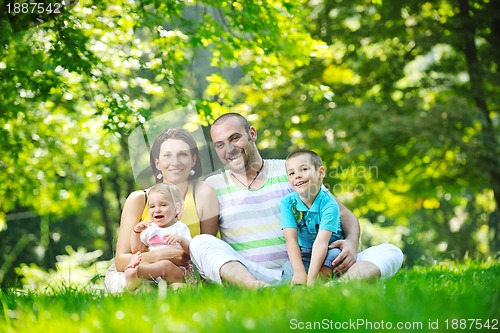 Image of happy young couple with their children have fun at park