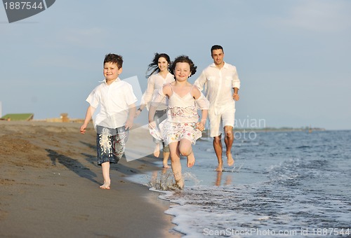 Image of happy young family have fun on beach at sunset