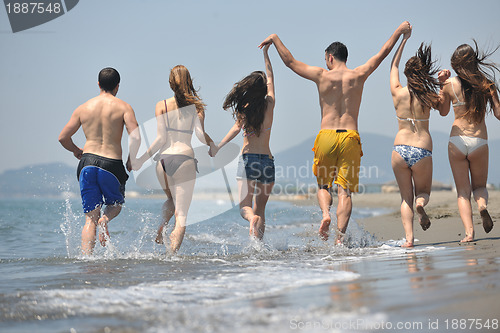 Image of happy people group have fun and running on beach