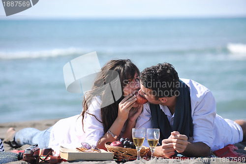 Image of young couple enjoying  picnic on the beach